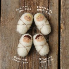 three small white and brown stuffed animals sitting on top of a wooden table