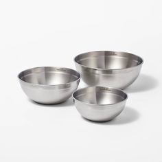 three stainless steel bowls on a white background