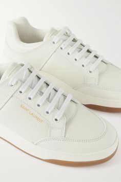 Find SAINT LAURENT Perforated Leather Sneakers on Editorialist. SAINT LAURENT's sneakers are made from panels of leather that are designed with tiny perforations for subtle texture and breathability. They're stamped with the logo in gold at the heel tab and rest on rubber soles. Wear yours with dresses, jeans or tailoring. Designer Leather Sneakers With Rubber Waffle Outsoles, Designer Lace-up Sneakers With Perforated Toe Box, Luxury Leather Sneakers With Perforations, Designer Leather Sneakers With Perforated Toe Box, Saint Laurent Sneakers, Studded Sneakers, White Leather Sneakers, White Sneakers Women, White Shoes Women