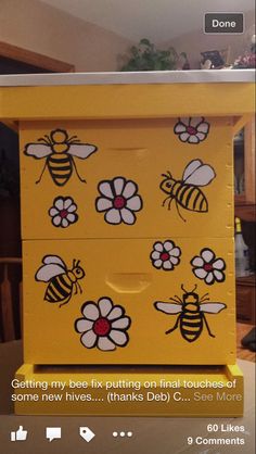 a yellow dresser with bees painted on the drawers and flowers drawn on the bottom part