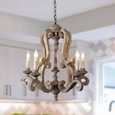 a chandelier with candles hanging from it's center piece in a kitchen