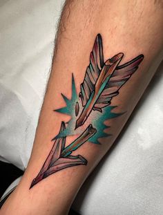 a man's arm with a colorful feather tattoo on the left side of his arm