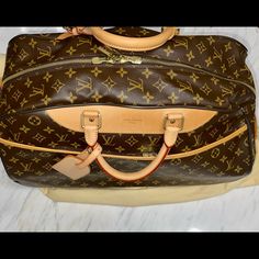 Used Once! Authentic Louis Vuitton “Lv” Monogram Eole 50 Rolling Duffel Bag. Excellent Condition Excluding Scratch Underneath Near Left Wheel. Brown And Tan Louis Vuitton Monogram Coated Canvas And Vachetta Leather Trim Eole 50 Rolling Duffle Bag With Brass Hardware, Rolled Handles, Zip Pocket At Exterior, Two Rolling Wheels, Retractable Pull Handle, Canvas Lining, Two Flat Pockets At Interior And Zip Closure At Top. Date Code. Includes Dust Bag. The Tag Is Monogrammed. One Owner. Rolling Duffle Bag, Louis Vuitton Keepall 45, Louis Vuitton Keepall 50, Louis Vuitton Travel, Louis Vuitton Speedy 35, Drawstring Purse, Louis Vuitton Speedy 30, Crossbody Bags For Travel, Louis Vuitton Keepall