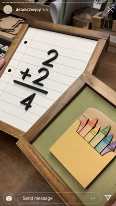 a wooden frame with some pictures and numbers in it on top of a table next to other items