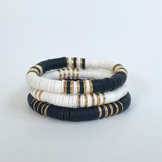 The Cruella bracelet stack will become your new daily go-to! The combination of black, white, and gold allows you to mix-and-match with so many other colors and styles.  I love to stack a few then add our Magnolia 14k gold bracelet.  Please note - each variation of the Cruella bracelet is available separately or snag them all as a set of 3!  Made with 8mm Heishi beads with gold brushed accent beads separating the color blocking 🌈Love neutrals, but looking for some color too?  🤍Our Fall/Jewel T Black White Jewelry, Heishi Bracelet Stack Ideas, Clay Bead Bracelet Ideas Black And White, Black And Gold Bracelet Stack, Black Heishi Bracelet Ideas, Neutral Bracelet Ideas, Clay Bead Bracelet Ideas Neutral Colors, Black And Gold Beaded Bracelets, Black And White Bracelets Beads