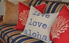 pillows on a couch with the words live love aloha written in blue and red