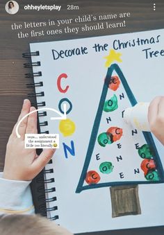 a child's hand is writing on a christmas tree coloring book with the words decorate the christmas tree