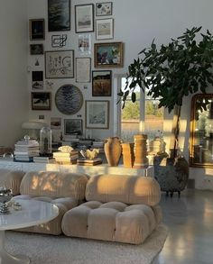 a living room filled with lots of furniture and pictures on the wall above it's windows