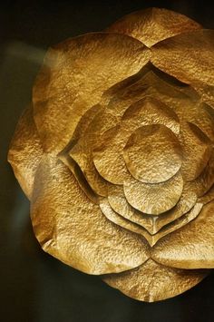 a large golden flower on top of a black table