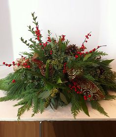 a bouquet of greenery and berries on a table