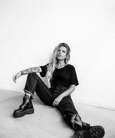 a black and white photo of a woman sitting on the floor