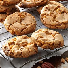 cookies cooling on a wire rack with nuts around them and some pecans in the background