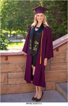 a woman in a graduation gown and cap poses for a photo at the school's commencement