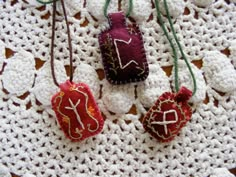 crochet doily with three small ornaments on top of it, one is red and the other is white