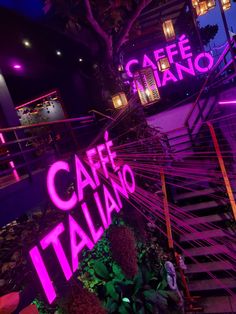 the stairs are lit up with neon lights and signs that read cafe italiano,