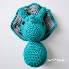 a crocheted blue elephant head on a white background