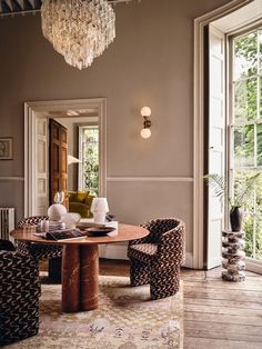 a dining room table with chairs and a chandelier hanging from it's ceiling