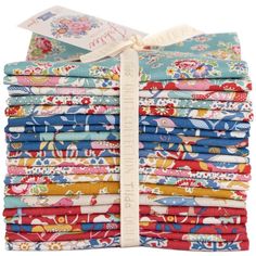 a stack of colorful fabric with a white ribbon