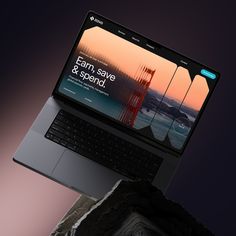 an open laptop computer sitting on top of a rock