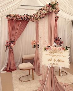 a wedding ceremony setup with pink flowers and drapes