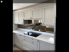 an empty kitchen with white cabinets and black counter tops is pictured in this image taken from the doorway