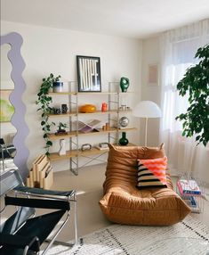 a living room filled with furniture and a potted plant next to a large window