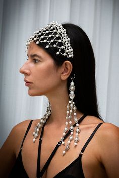 a woman wearing a head piece with pearls on it