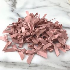 a pile of pink ribbon on top of a marble counter