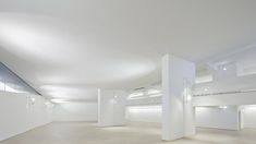 an empty room with white walls and flooring is shown in this image, there are several lights on either side of the wall