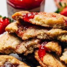 strawberry shortbreads stacked on top of each other next to some strawberries and jam