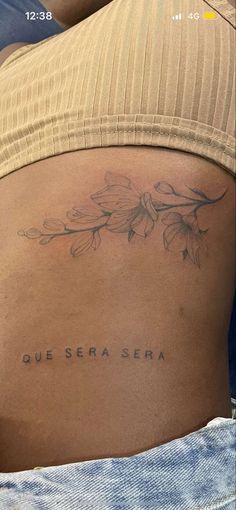 the back of a woman's stomach with an inscription on it that says que sera sera