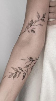 a woman's arm with leaves on it