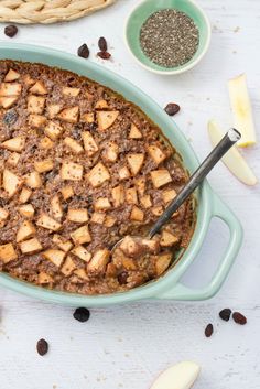 a casserole dish with meat and cheese on the side next to other dishes