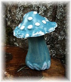 a small blue mushroom sitting on top of a wooden table