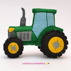 a green toy tractor sitting on top of a white table