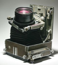 an old camera with a lens attached to it's body and some metal parts