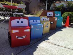 some cars made out of cardboard boxes sitting on the ground