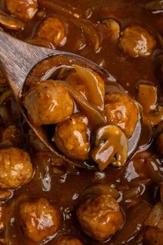 a wooden spoon filled with meatballs and gravy