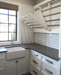 an empty kitchen with white cabinets and black counter tops is seen in this image, while the window looks out onto the street