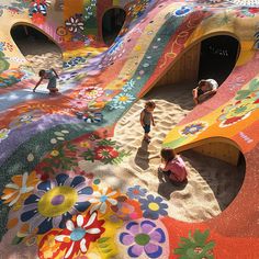 children are playing in the sand at an art installation