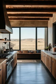 a kitchen with wooden cabinets and an open window looking out onto the desert landscape outside