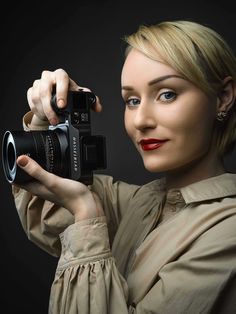 a woman holding a camera up to her face