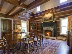 a large dining room with wood paneled walls and beams on the ceiling, along with a fireplace