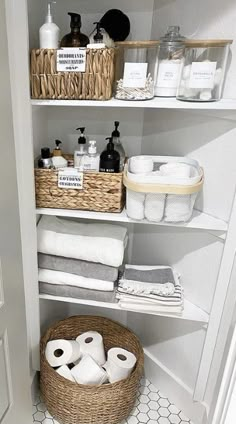 an organized bathroom with toilet paper and baskets