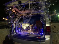 the trunk of a car is decorated with blue lights and white string work on it