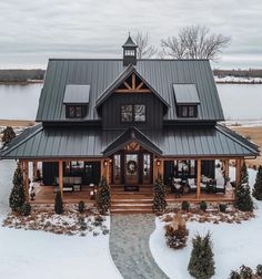 an aerial view of a large house in the winter with snow on the ground and trees around it