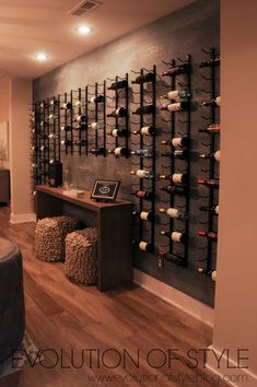 the wine rack in the room is filled with many bottles and glasses on it's wall