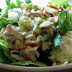 a salad with chicken and lettuce in a white bowl