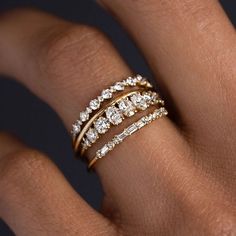 a woman's hand with three different rings on her finger and the ring is made out of gold