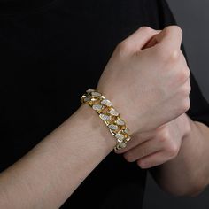 Put some Cuban flavor into your style with this 18mm Cuban link bracelet. It's crafted with high quality gold plating and adorned with cubic zirconia stones for a touch of luxury. The Cuban link design is classic and stylish, and it's sure to make a statement whether you're dressing up or dressing down.This bracelet is the perfect way to add a little bit of edge to your outfit. Whether you're going for a night out on the town or just hanging out with friends, this bracelet will help you make a s Gold Cuban Link Bracelet With Cubic Zirconia, Gold Cuban Link Chain Bracelet With Cubic Zirconia, Iced Out Gold Chain Link Bracelet, Gold Cubic Zirconia Chain Link Bracelet, Gold Iced Out Tennis Bracelet, Gold Cubic Zirconia Bling Bracelets, Gold Cuban Link Bracelet Iced Out In Cubic Zirconia, Gold Cuban Link Bracelet Iced Out With Cubic Zirconia, Gold Iced Out Cuban Link Bracelet